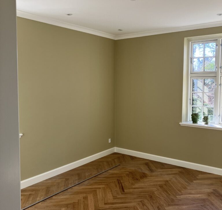 Lyst tomt rum med parketgulv og vindue