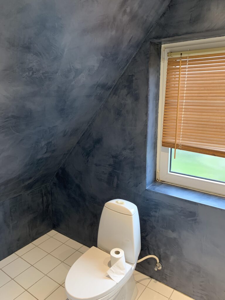 Moderne badeværelse med toilet og blå vægge